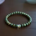 Macro detail of green sandalwood beads with a translucent amber-like gemstone bead - 6mm / Green Sandalwood & Yellow Crystal