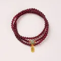 Triple-wrap garnet bead bracelet featuring a green jade bead and a golden Fu charm - Qingshui Hetian Jade & Fu Tag Style / 4mm Bead Diameter / Triple-Wrap / Burgundy