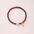 Garnet beaded bracelet featuring a white jade bead and a golden Fu character pendant - Qingshui Hetian Jade & Fu Tag Style / 4mm Bead Diameter / Single-Wrap / Burgundy