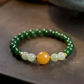 Macro shot of natural jasper beads with amber accents and gold spacers on wood - 8mm Green Jade 12mm Amber Gold Plated Silver Bracelet