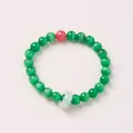 Close-up of green cat's eye beads with red accent and pale green ring on a beaded bracelet - Green Cat's Eye Faux Rhodochrosite Chalcedony