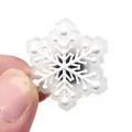 Macro view of a 3D white snowflake shoe charm for clogs with a black circular fastener - Snowflake Style Buckle