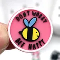 Gros plan du charm de chaussure en PVC rose avec abeille et texte Don't Worry Bee Happy - Plaque Ronde Abeille