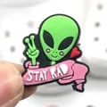 Détail d'un charm de chaussure extraterrestre vert avec ruban Stay Rad pour sabots - Alien Signe de Paix
