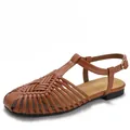 Retro brown woven leather T-strap flat sandals with golden buckle on white background - EU 36 / Brown
