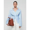 Lichtblauwe blouse met lange mouwen en knoopdetail met stijlvolle bruine handtas - S / Blauw