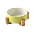 Minimalist ceramic pet bowl with light yellow matte exterior and wooden elevated stand - Small
