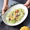 White oval ceramic serving plate for pasta salad held by hands in a warm home setting - Large Oval Plate (MM2812-2) / White