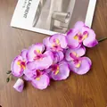 Dettaglio di orchidea artificiale con petali viola e boccioli su legno scuro - Spring Light Purple