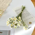 Artificial white chamomile bouquet with yellow centers on a rustic table background - White