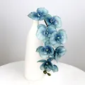 Künstlicher blauer Orchideenzweig mit Farbverlauf in einer eleganten weißen Keramikvase - Herbstblau