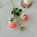 Single artificial silk rose with gradient pink petals and green leaves on a white tablecloth - Border Pink