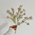 Artificial babys breath bouquet with white and purple flowers held by a hand - Purple