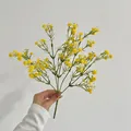 Vibrant yellow artificial baby's breath bouquet with green stems held in hand - Yellow