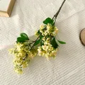 Realistic light yellow artificial clove flowers with green leaves on white waffle fabric - Yellow