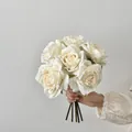 Elegant white vintage silk roses bouquet held against a minimalist grey background - White