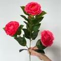 Künstlicher rosa Kamelienzweig mit drei blühenden Blütenköpfen und realistischen Blättern - Rosenrot