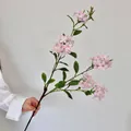 Pink and white faux phlox flowers with long green stems held by hand for home decor - Pink