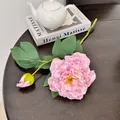 Roze kunstmatige pioenroos tak met grote bloem en knop op een donkere houten tafel - Paars