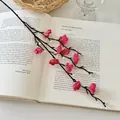 Rama de flor de ciruelo artificial rojo rosa sobre un libro abierto para decoración - Mini Flor de Invierno Rojo Rosa