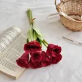 Mazzo di sei tulipani artificiali rosso scuro legati con spago su un tessuto bianco - Rosso