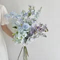Elegant blue faux roses and hydrangea bridal bouquet held by a model for home decor - Ocean Tears Bouquet