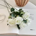 Artificial white rose bouquet with green leaves placed on a book for home decor - White