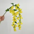 Mano sosteniendo una enredadera de lirio de los valles artificiales amarillos - Amarillo
