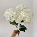 Elegant white artificial French hydrangea bouquet held by a person for size reference - White