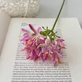 Rosa Schmucklilie Kunstblumenstrauß aus Seide auf einem antiken Buch platziert - Rosarot