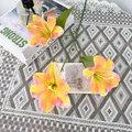 Künstliche Lilie mit drei Köpfen, orange-rosa Farbverlauf und grünen Blättern auf Spitze - Orange