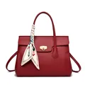 Elegant red leather handbag with lychee texture, golden ring clasp and floral scarf decor - Red