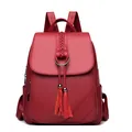Women's dark red leather backpack with tassel charms and luxury pebble texture - Red