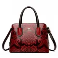 Sac à main rouge et marron avec motifs floraux gaufrés et emblème de kangourou - Bordeaux