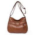 Dark brown washed leather crossbody bag with multiple zippers and adjustable strap - Tan