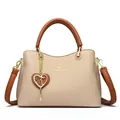 Elegant beige and brown leather handbag with gold kangaroo logo and heart charm detail - Light Khaki