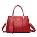 Elegant red leather handbag with gold kangaroo logo and adjustable crossbody strap - Red