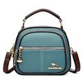 Teal and brown lychee grain leather crossbody bag with golden kangaroo hardware logo - Blue