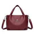 Deep burgundy leather bucket bag with top handles and adjustable shoulder strap - Red
