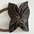 Close-up of brown floral hair scrunchie with handmade label on vintage wooden background - Large Square / Coffee Floral