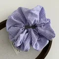Detail of purple gingham hair scrunchie on a display tray with a high-quality fabric texture - Purple