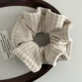 Detailed macro view of beige corduroy hair scrunchie texture in a wooden tray - Apricot