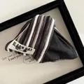 Close-up of the black and white striped fabric hair clip featuring a Black Cat woven label - Vintage Grey