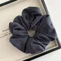 Detail shot of a dark grey ribbed knit scrunchie on a decorative display tray - Navy Blue