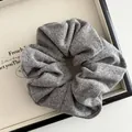 Detailed macro view of gray knitted scrunchie fabric texture on a white display board - Gray
