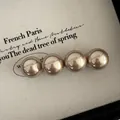 Detailed view of four champagne gold metallic pearls on a French vintage hair clip - Champagne