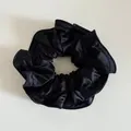 Vue détaillée de la texture en satin noir lisse et des plis du chouchou élastique - Noir