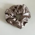Détail du chouchou en satin champagne montrant le lustre métallique et les bords cousus - Café au Lait