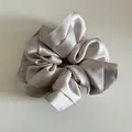 Detail shot of oversized champagne satin scrunchie showing smooth silk texture and soft pleats - Champagne