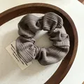 Gros plan du chouchou en maille côtelée marron avec texture verticale détaillée - Brun